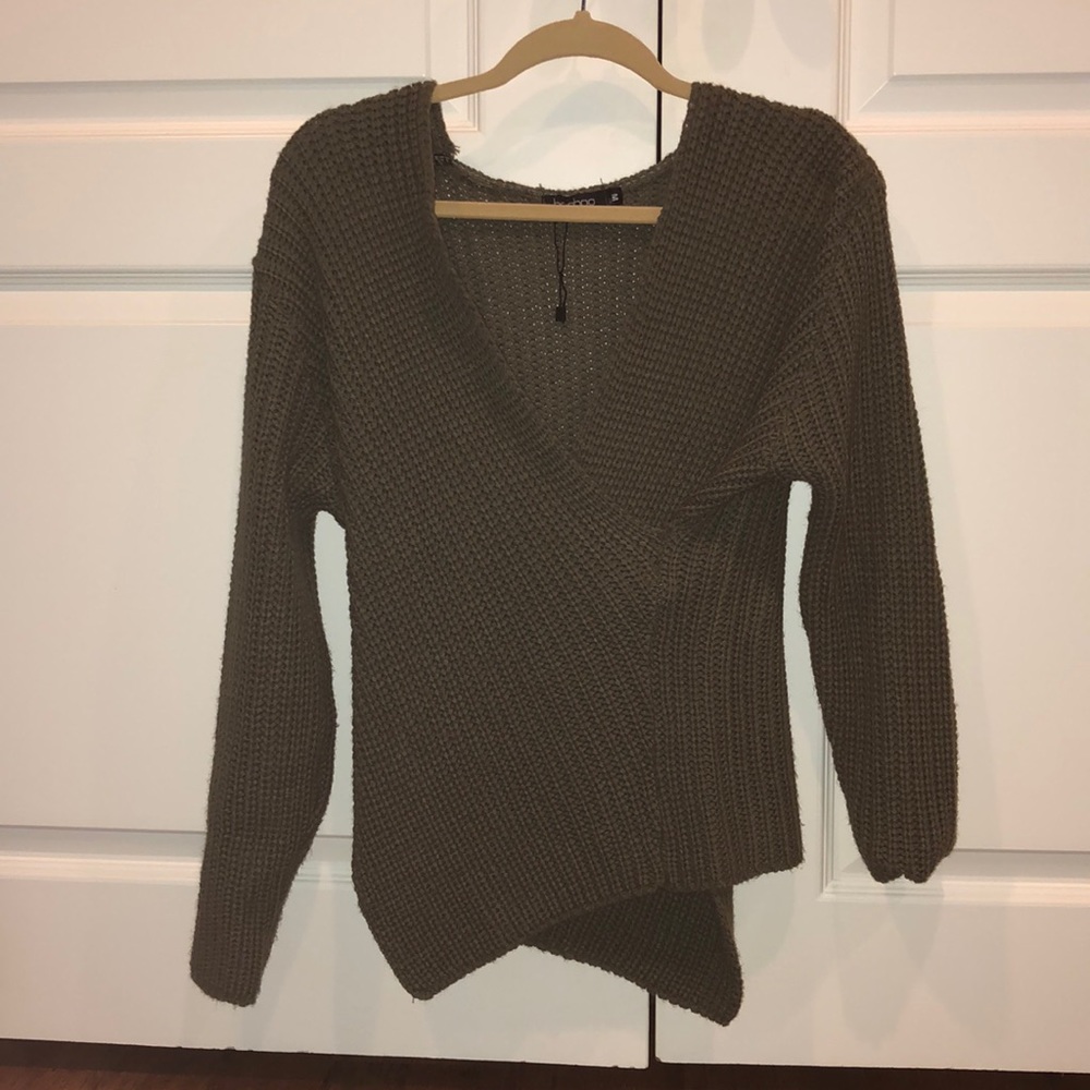 A green asymmetrical sweater